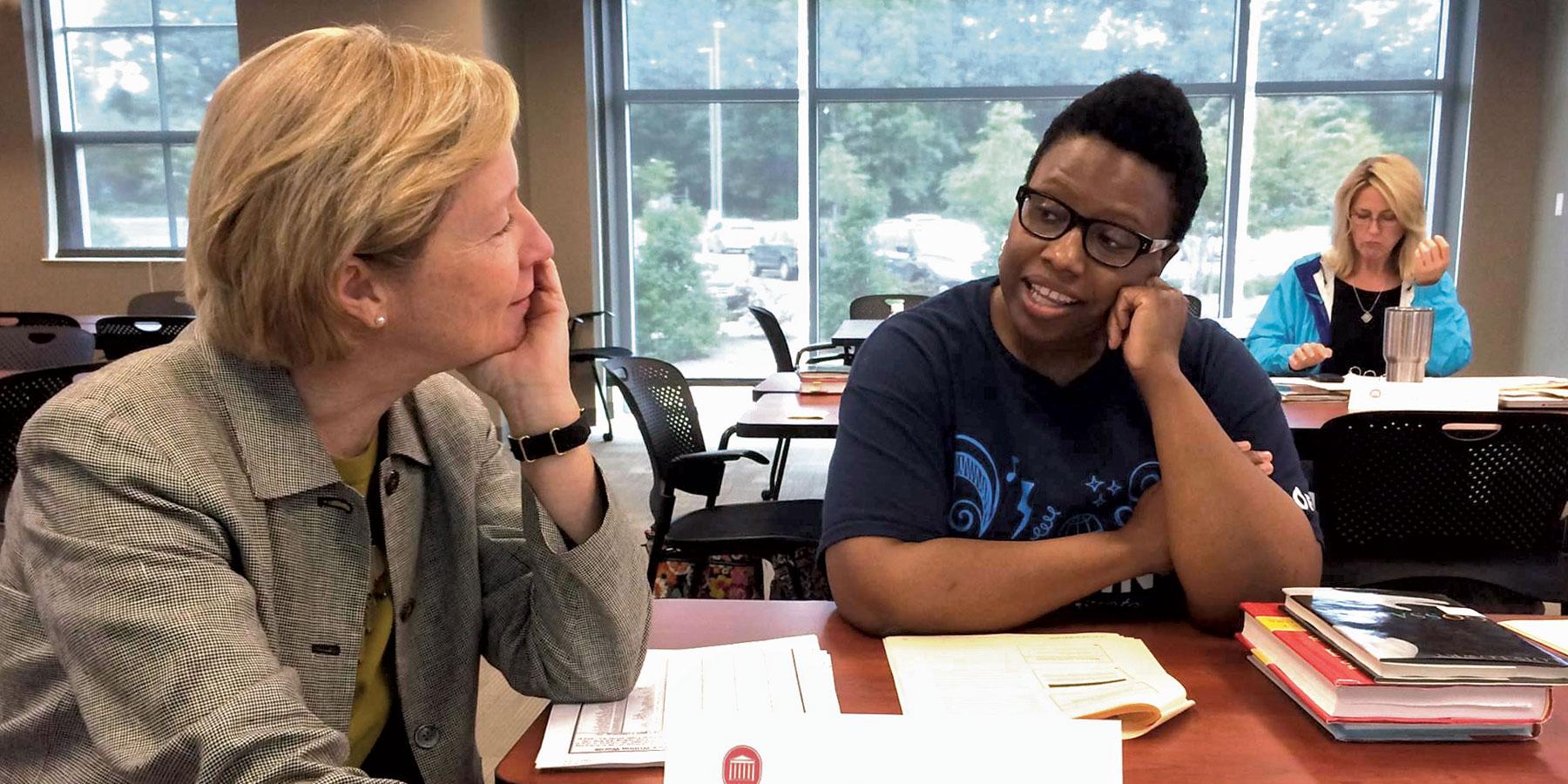 Kelly Butler (left) discusses literacy and leadership with a Mississippi principal during a professional development session.