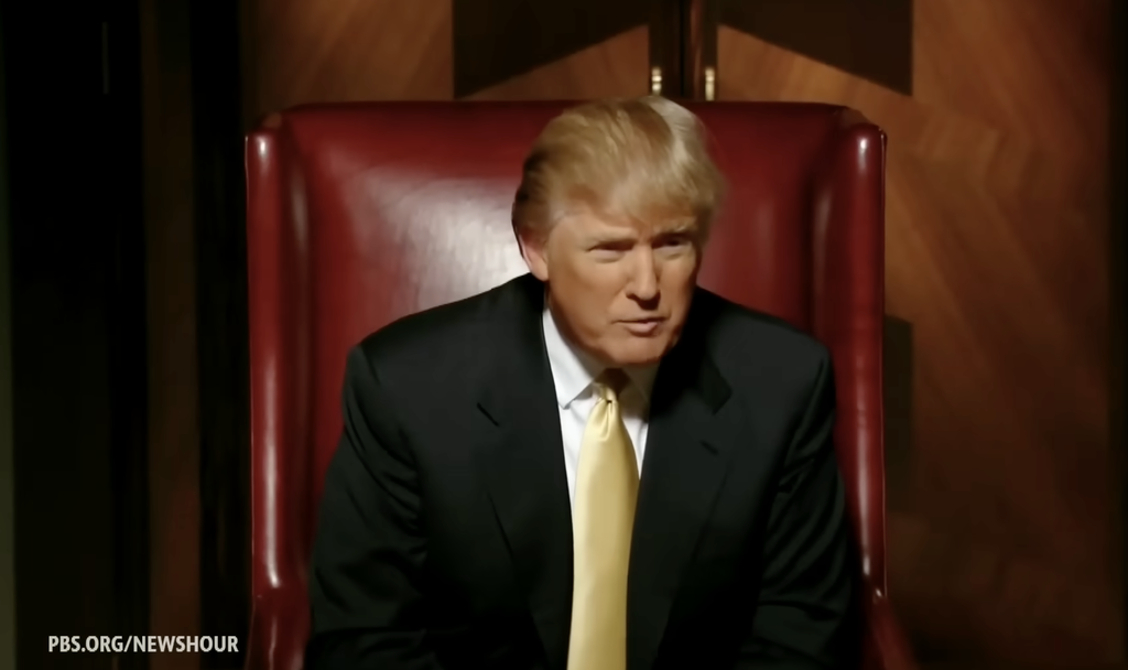 A video still from NBC's The Apprentice showing Donald Trump seated in a large red leather chair, used to illustrate how his reality TV experience contributed to his political rise.