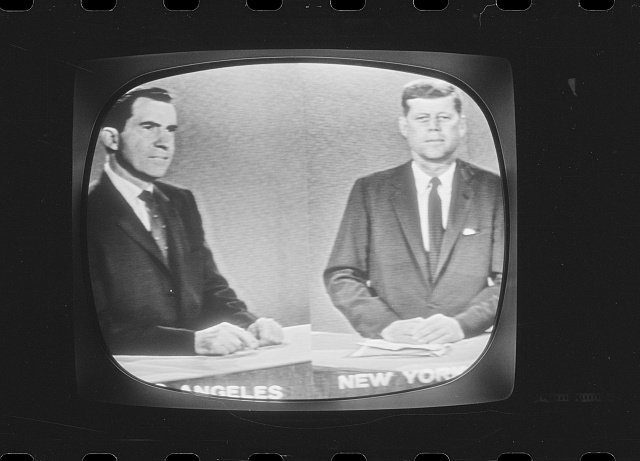 A black-and-white photograph of a television screen showing the third 1960 presidential debate between Vice President Richard Nixon, appearing from Los Angeles, and Senator John F. Kennedy, appearing from New York.